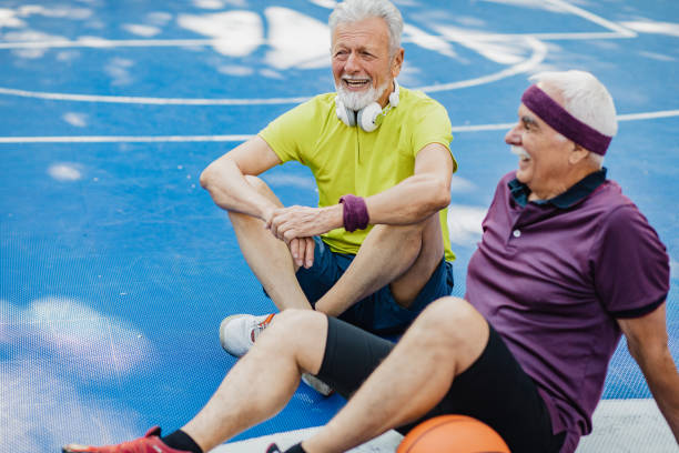 istock Two active senior men on basketball field taking a break from sport activity 1328350051