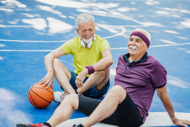 istock Two active senior men on basketball field taking a break from sport activity 1328350100