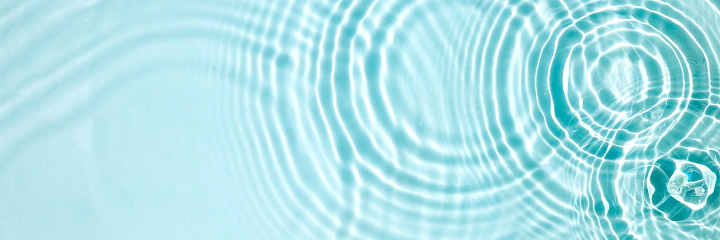 Water background. Blue water texture, blue mint water surface with rings and ripples. Spa concept background. Flat lay, top view, copy space.