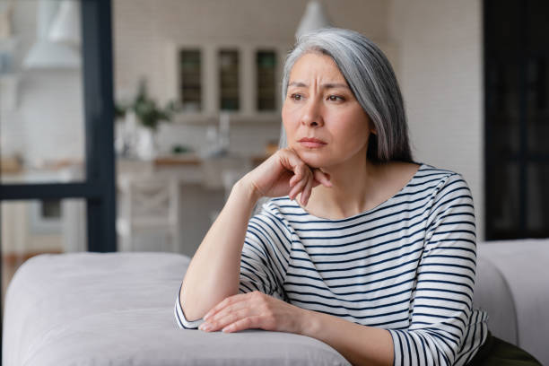 悲しい落ち込んだ疲れた孤独な離婚した病気の母親の成熟した女性は気分が悪く、不健康で、ロックダウン、社会的距離のミッドライフ危機に苦しんでいます - menopause ストックフォトと画像