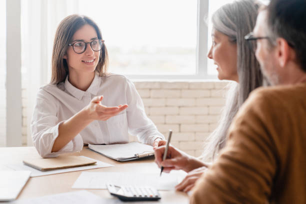 agent d’assurance avocat conseiller financier courtier discuter de la consultation d’un couple d’âge moyen mature signant des documents contractuels, l’achat d’une propriété, des investissements à la maison - income insurance photos et images de collection