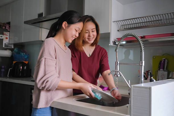 istock mother and daughter washing dishes 1328353066