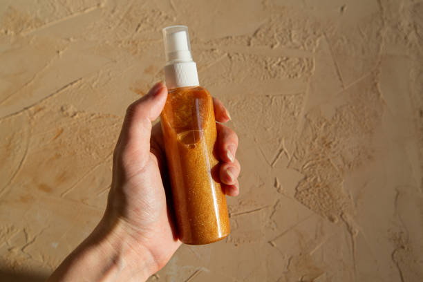 istock hand holds shiny tanning spray to protect skin 1328353094