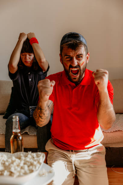 istock Winning and loosing expressions while watching the tense football game 1328358579