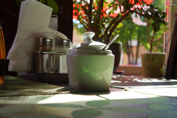 Breakfast by window at sunny morning. Sugar bowl on table. Selective focus.