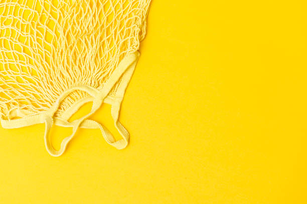 istock Empty mesh bag for shopping on a yellow background isolated. Zero waste shopping concept 1328358886