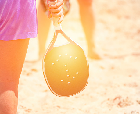 Mujer jugando al tenis de playa en una playa. Concepto de deporte profesional photo