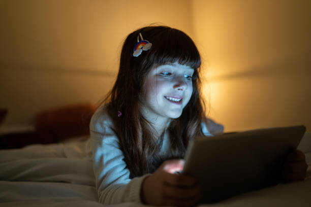 istock Happy girl lying on the bed using digital tablet at home 1328360247
