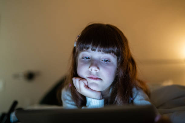 istock Girl lying down on bed using a digital tablet at home 1328360368