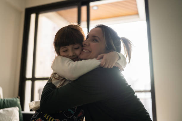 istock Mother and daughter embracing at home 1328360409