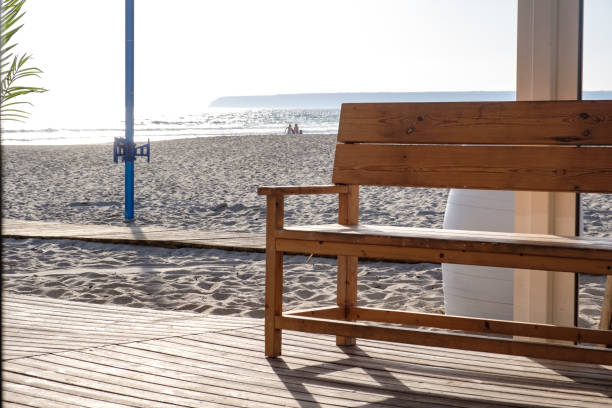 istock Wooden bench on beach by the sea 1328360718
