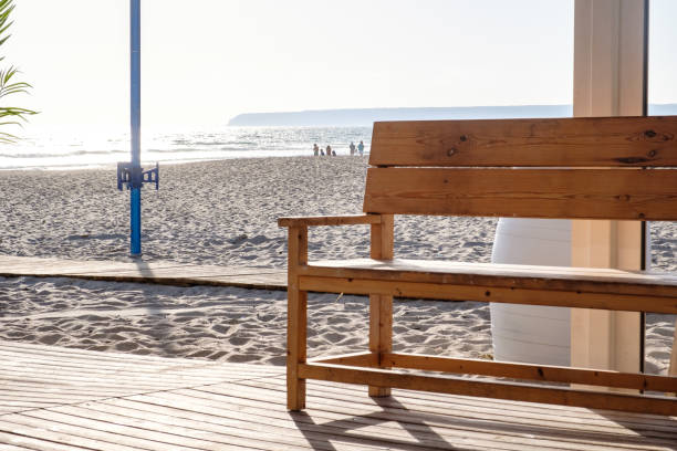 istock Wooden bench on beach by the sea 1328361430