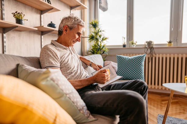 istock Senior man relaxing at home and reading a book 1328363954