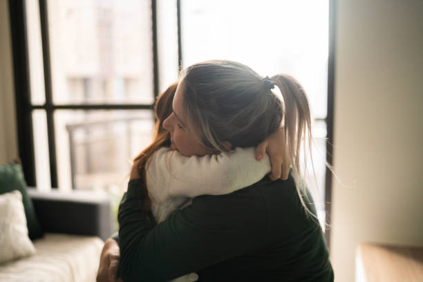 istock Mother and daughter embracing at home 1328364332