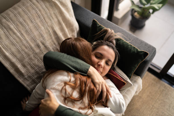 istock Mother and daughter embracing at home 1328364337