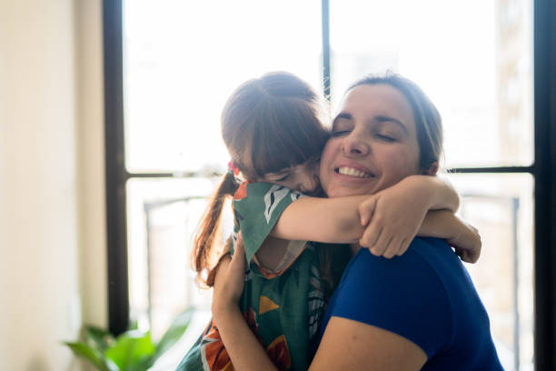 istock Mother and daughter embracing at home 1328364424