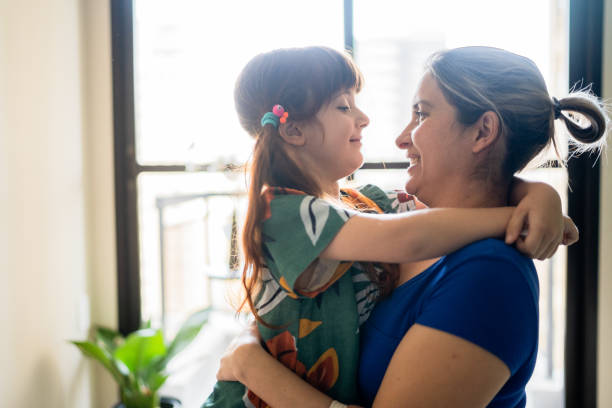 istock Mother and daughter embracing at home 1328364448
