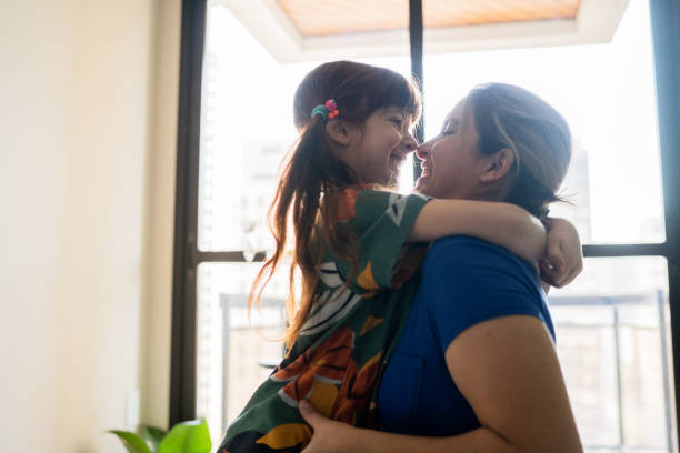 istock Mother and daughter embracing at home 1328364515