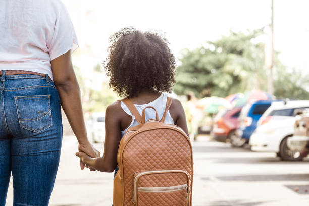 little girl with backpack holds a person's hand. back to school concept. little girl with backpack holds a person's hand. back to school concept. backpack photos stock pictures, royalty-free photos & images