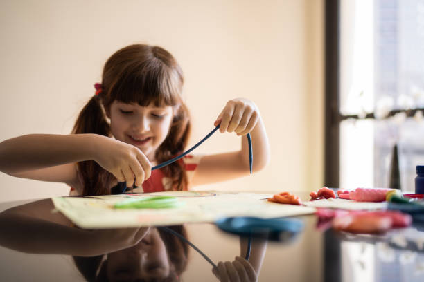 istock Cute girl doing art project at home 1328364652