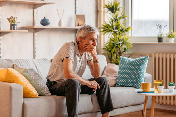 istock Man sitting alone at home looking sad and distraught 1328364666