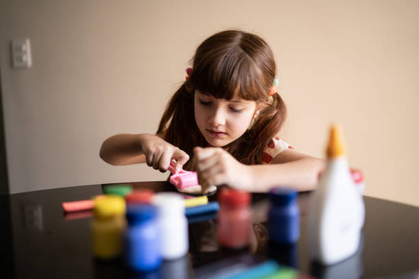 istock Cute girl doing art project at home 1328364715