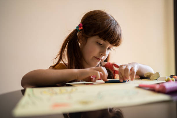 istock Cute girl doing art project at home 1328364737