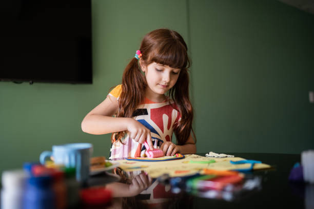 istock Cute girl doing art project at home 1328364751