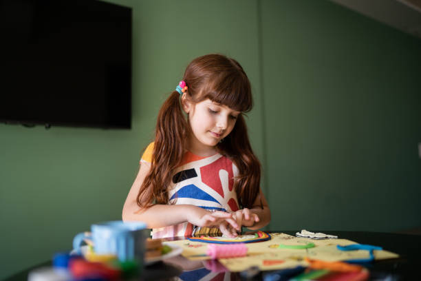 istock Cute girl doing art project at home 1328365270