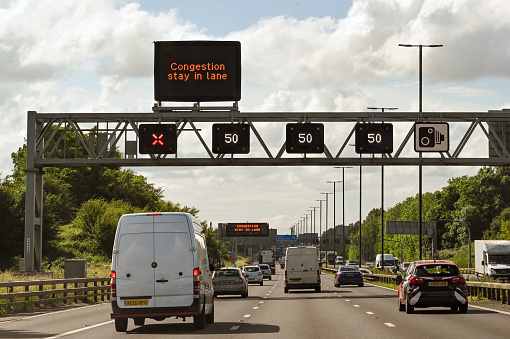 Bristol, England - June 2021: Overhead gantry on the M4 motorway with road signs showing the speed limit and a closed lane.