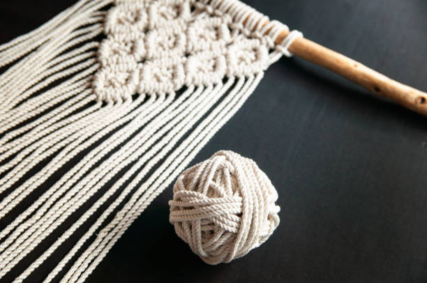istock Handmade macrame 100 cotton wall decoration with wooden stick hanging on a white wall. Modern decoration in the interior. 1328370834