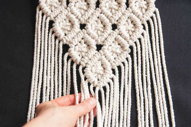 istock Handmade macrame 100 cotton wall decoration with wooden stick hanging on a white wall. Modern decoration in the interior. 1328370863