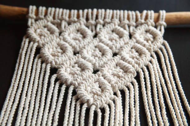 istock Handmade macrame 100 cotton wall decoration with wooden stick hanging on a white wall. Modern decoration in the interior. 1328370891