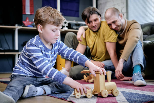 istock Gay Couple Looking at Playing Son 1328373596