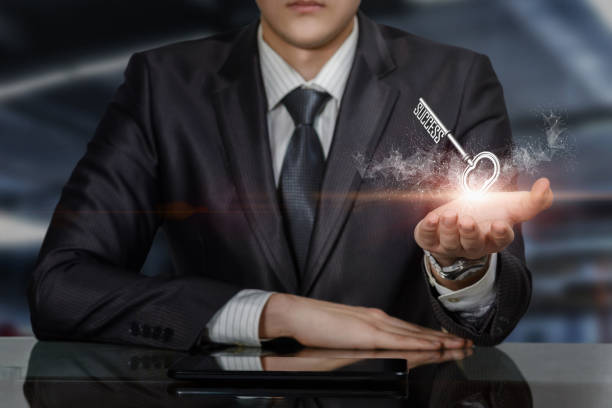 Businessman at the table shows the key to success Businessman at the table shows the key to success on a blurred background. turnkey project stock pictures, royalty-free photos & images