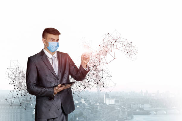 istock Businessman in a protective mask works the network against . 1328375247