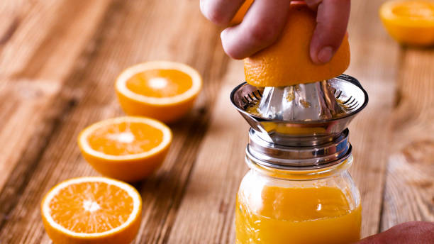 making fresh orange juice with a handheld orange juicer. - 榨汁機 個照片及圖片檔