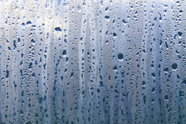 istock Texture of rain drops on a glass wet transparent surface. 1328383774