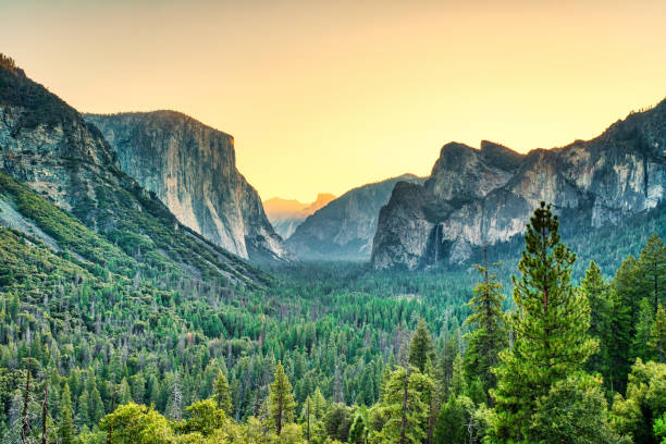 vue illuminée de la vallée de yosemite depuis l’entrée du tunnel de la vallée à sunrise, parc national de yosemite, californie - yosemite national park waterfall half dome california photos et images de collection