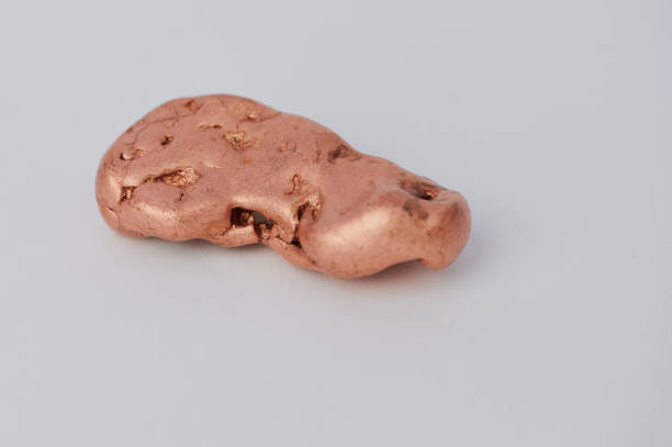 single copper nugget against white background stock photo