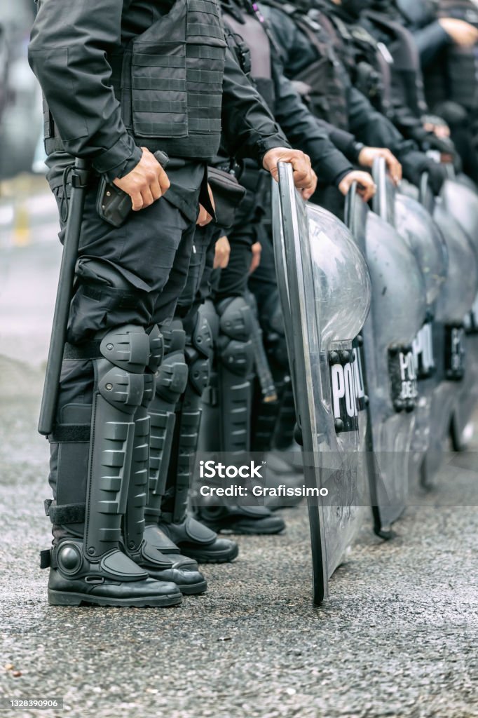Police officers in armored clothing on duty during street protest Police Brutality Stock Photo