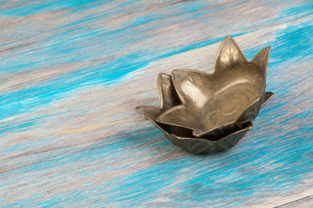 Two old bronze candlesticks on blue wooden background. Copy space for text.