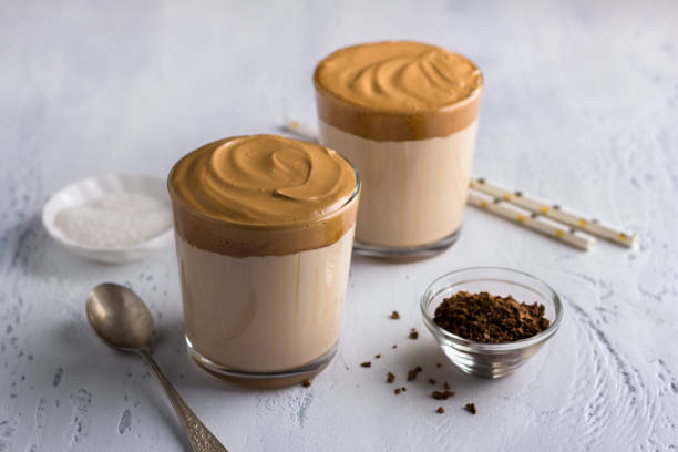 istock Two glasses with Dalgona coffee, cold cocktail with whipped coffee foam, popular trending drink on a light textured background 1328393049