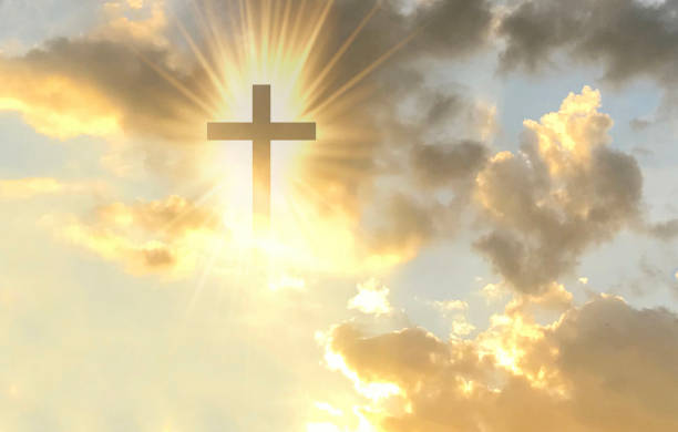 istock Christian cross appears bright in the gold sky 1328394814