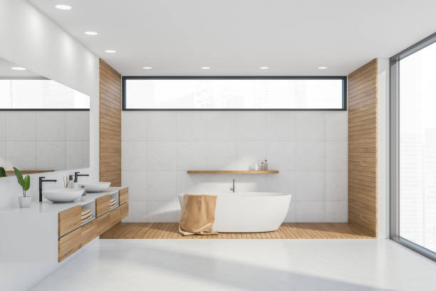 istock White bathtub in panoramic white bathroom interior with narrow window 1328396056