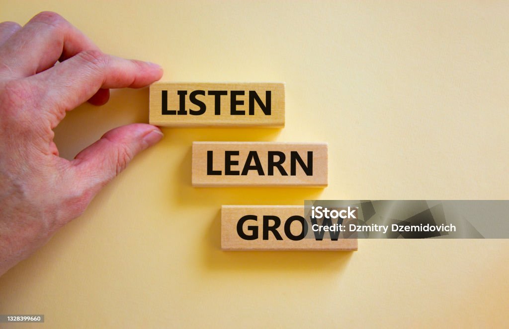 Listen, learn and grow symbol. Wooden blocks with concept words listen, learn, grow. Beautiful white background. Businessman hand, copy space. Business, educational and listen, learn, grow concept. Listening Stock Photo