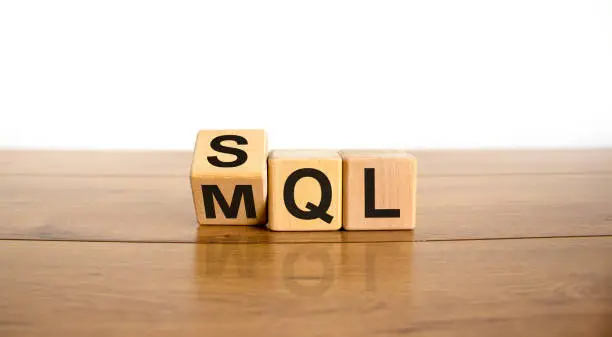 Photo of SQL or MQL symbol. Turned wooden cubes and changed words 'MQL marketing qualified lead' to 'SQL sales qualified lead'. Beautiful white background. Business and SQL or MQL concept. Copy space.