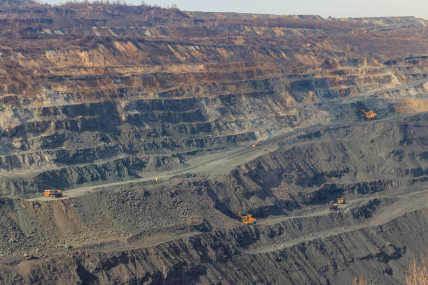 istock Huge iron ore quarry with working dump trucks and excavators 1328400049