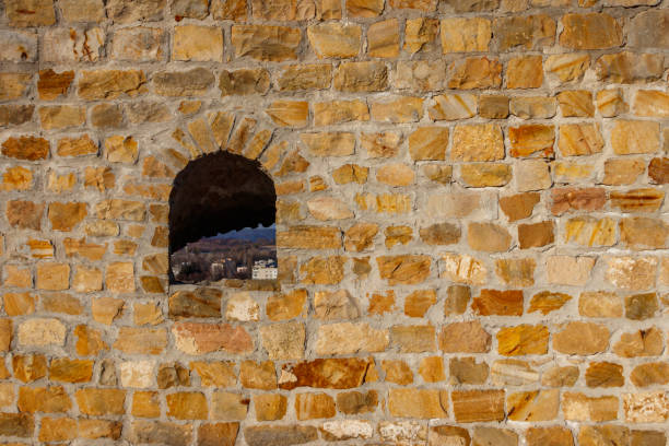 Background of the old stone wall with a loophole