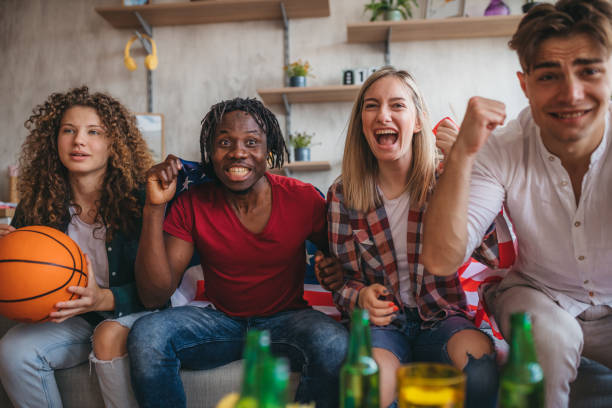 istock Friends are watching a basketball game and cheering. 1328401576